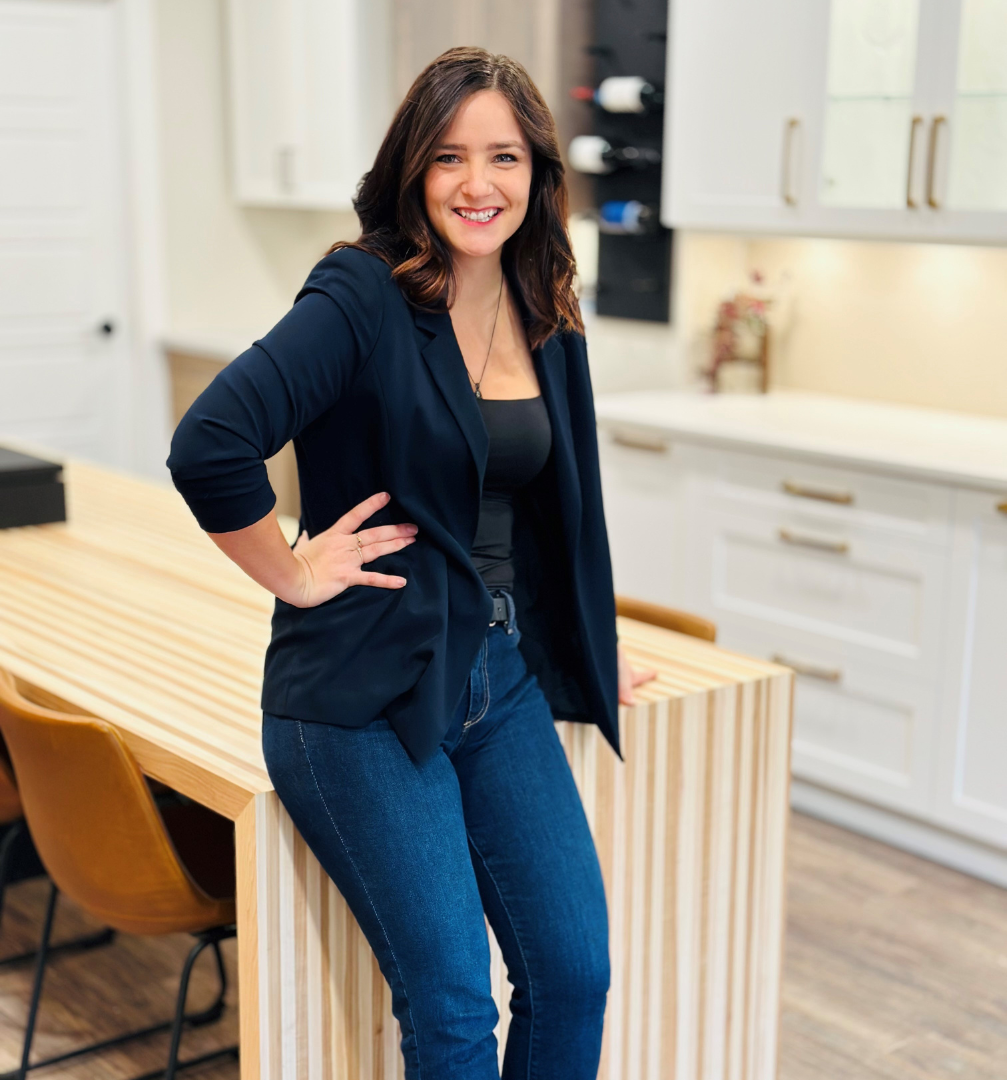 Untitled design (89) A woman standing in front of a kitchen island.